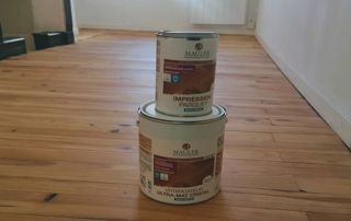 deux pots de peinture l'un sur l'autre sur le sol